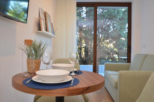a dining room table with wine glasses and a couch at Oliva Teles 53 Apartments in Arcozelo