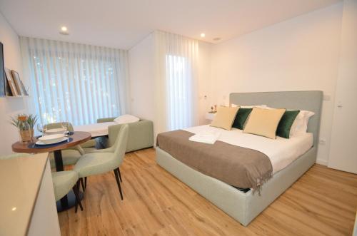 Schlafzimmer mit einem Bett, einem Schreibtisch und einem Tisch in der Unterkunft Oliva Teles 53 Apartments in Arcozelo