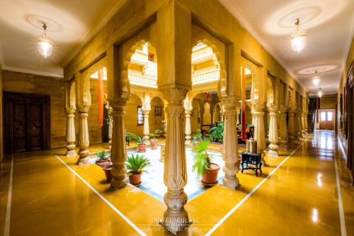 a large building with columns and potted plants at The Gulaal in Jaisalmer