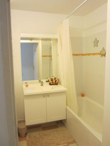 une salle de bain avec un lavabo, une baignoire et un miroir dans l'établissement SUPERBE APPART AVEC JARDIN ET PISCINE, à Cambo-les-Bains