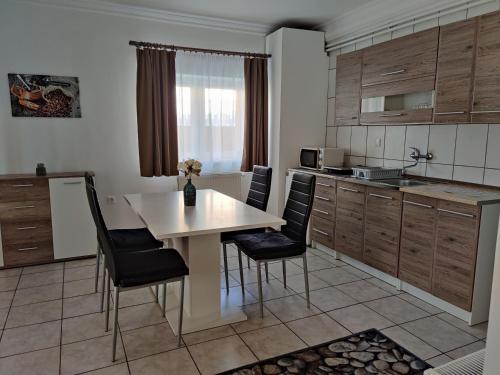 una cucina con tavolo e sedie in una cucina di Katalin Apartmanház a Miskolctapolca