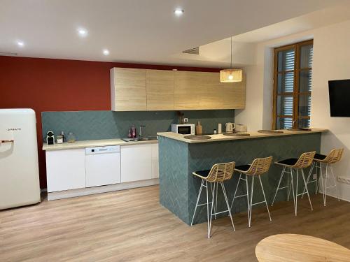 une cuisine avec un comptoir et un bar avec tabourets dans l'établissement Le Bout du Monde Appartement Hyper-centre, à Carcassonne