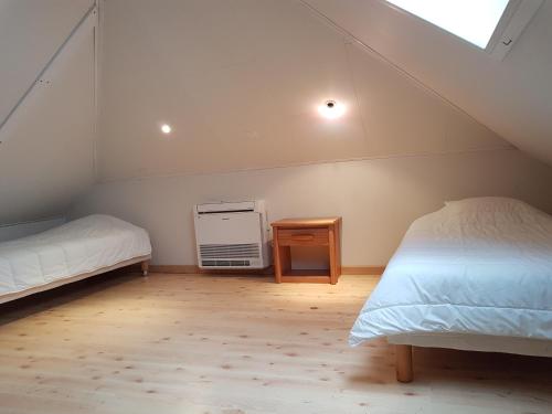Schlafzimmer im Dachgeschoss mit 2 Betten und einem Nachttisch in der Unterkunft Villa Laia-clim-WIFI- vue mer in Conca