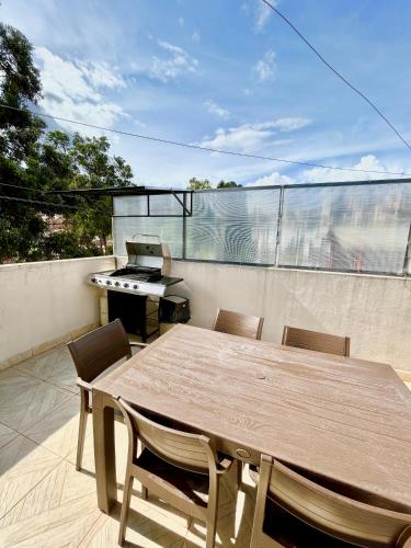 a table and chairs on a balcony with a grill at VFC Suites Cuenca - Ecuador in Cuenca