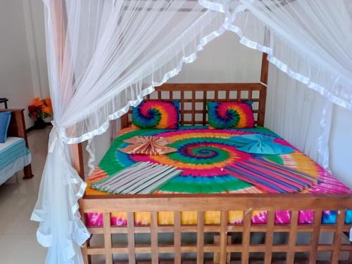 a colorful bed with a canopy in a room at Resort of Happiness in Mirissa
