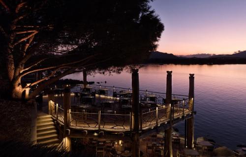 a dock with a restaurant on the water at sunset at Hôtel Le Belvédère in Porto-Vecchio