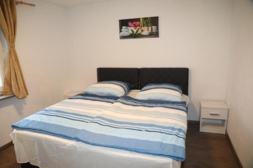 - un lit avec deux oreillers et une photo sur le mur dans l'établissement Ferienwohnung Kassel, à Cassel