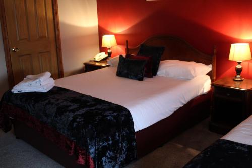 a hotel room with two beds with red walls at Bridge Hotel in Arklow