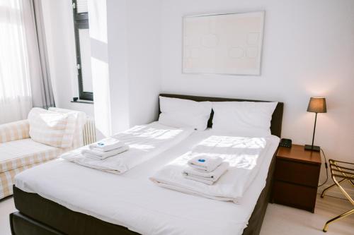 a bedroom with a bed with two towels on it at Boutique Hotel Villa Oberkassel in Düsseldorf