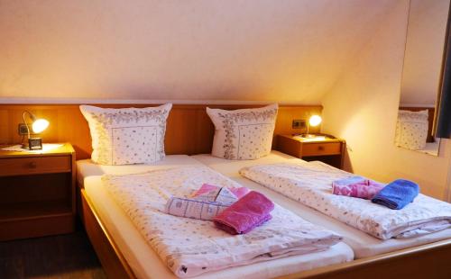 een slaapkamer met 2 bedden en kussens erop bij Haus Shalom in Neuharlingersiel