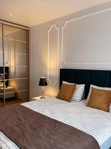 a bedroom with a large bed with a blue headboard at Апартаменты NEO в жк Империал in Truskavets