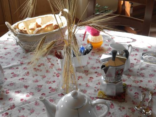 L'Isola Che Non C'era في Apiro: طاولة مع وعاء الشاي وسلة من الخبز