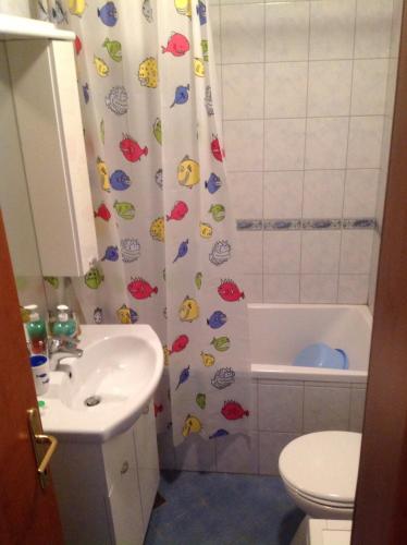a bathroom with a shower curtain with a toilet and a sink at Apartment Biserka in Cavtat