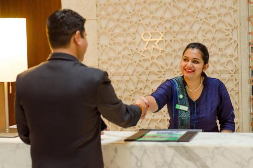 a man and a woman shaking hands at a table at Holiday Inn Jaipur City Centre by IHG in Jaipur