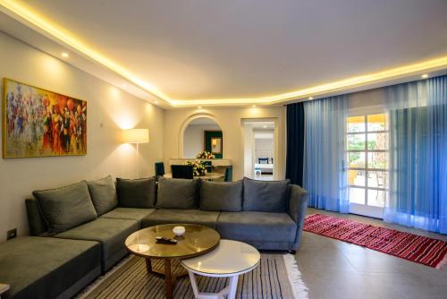 a living room with a couch and a table at Suites Hôtel Les Charmilles & Spa in La Marsa