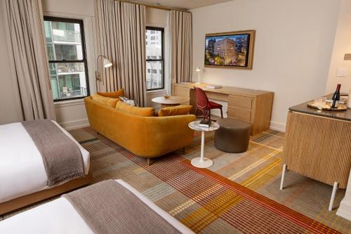 ein Hotelzimmer mit einem Bett, einem Sofa und einem Schreibtisch in der Unterkunft Hotel Andra Seattle MGallery Hotel Collection in Seattle