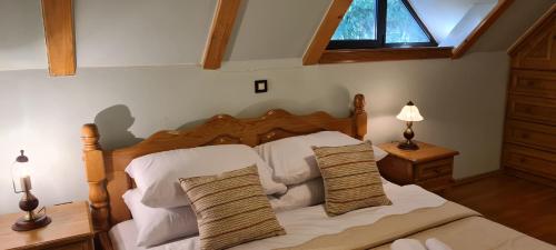 sypialnia z łóżkiem z białymi poduszkami i oknem w obiekcie Kuća za odmor Gorski san w mieście Lokve