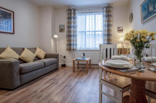 a living room with a couch and a table at Arcadia - 1 Bedroom Apartment - Tenby in Tenby