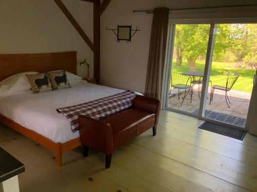 a bedroom with a bed and a chair and a patio at Shoreham Inn Bed & Breakfast in Shoreham