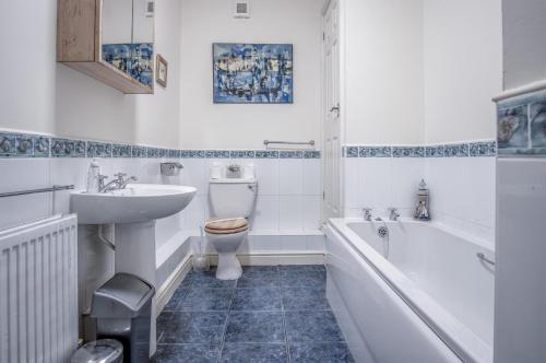 a bathroom with a sink and a toilet and a bath tub at Arcadia - 1 Bedroom Apartment - Tenby in Tenby