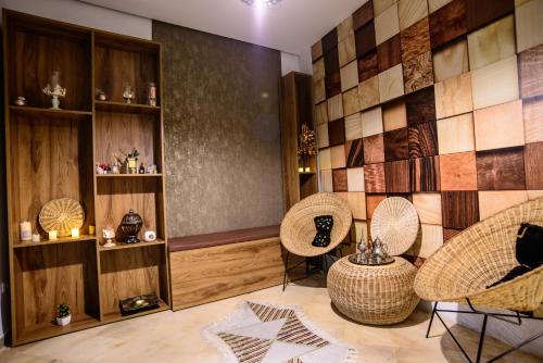 a room with chairs and a tiled wall at Suites Hôtel Les Charmilles & Spa in La Marsa