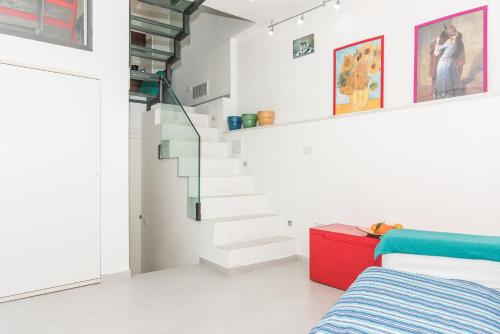 a bedroom with white walls and a stair case at Casa del Borgo by Arbaspàa in Riomaggiore