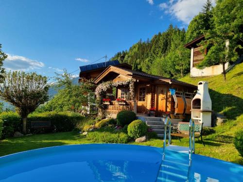 uma casa com uma piscina em frente em Holiday Home Egger - ZAZ379 by Interhome em Aschau