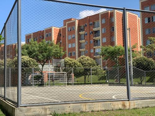 a tennis court in front of some buildings at Apartamento amoblado nuevo in Pereira
