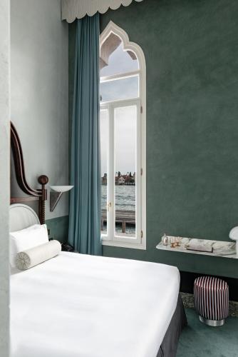 a bedroom with a white bed and a window at Il Palazzo Experimental in Venice
