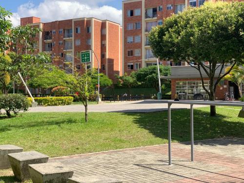 a park with a bench and trees and buildings at Apartamento amoblado nuevo in Pereira