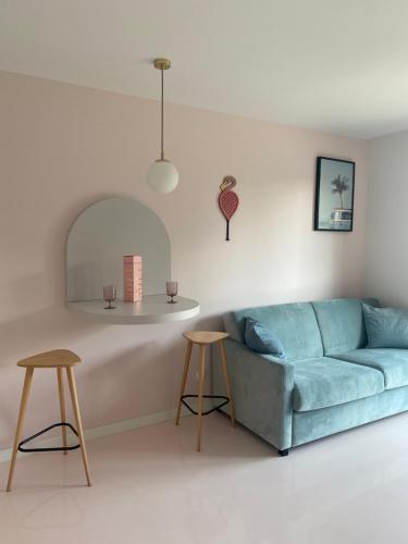 a living room with a blue couch and two stools at Flaming Apartment Gdańsk Wrzeszcz in Gdańsk