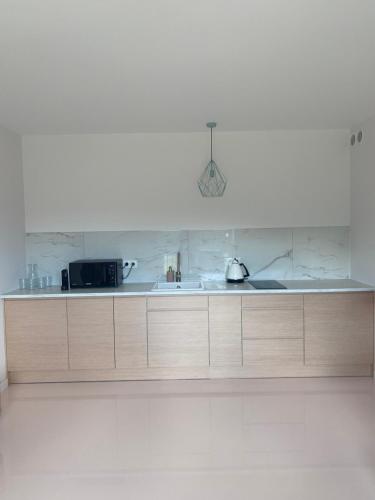 a kitchen with a sink and a microwave at Flaming Apartment Gdańsk Wrzeszcz in Gdańsk