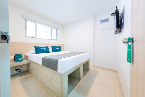 a bedroom with a bed with blue pillows on it at Ayenda Panamericana in Manizales