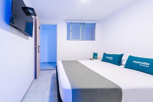 a bedroom with a large bed and a flat screen tv at Ayenda Panamericana in Manizales