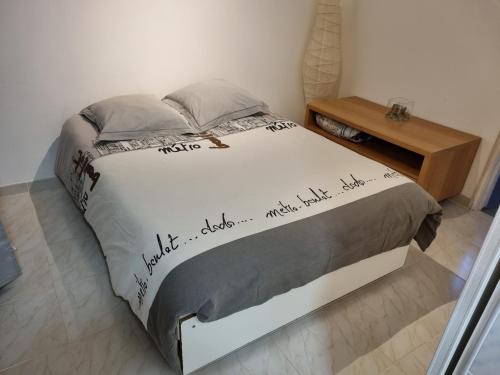 uma cama com escrita num quarto em destroisterrasses em Caux