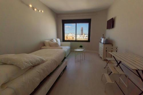 sypialnia z łóżkiem, kanapą i stołem w obiekcie RentalSevilla Resitur II w Sewilli