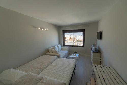 sypialnia z łóżkiem, kanapą i krzesłem w obiekcie RentalSevilla Resitur II w Sewilli