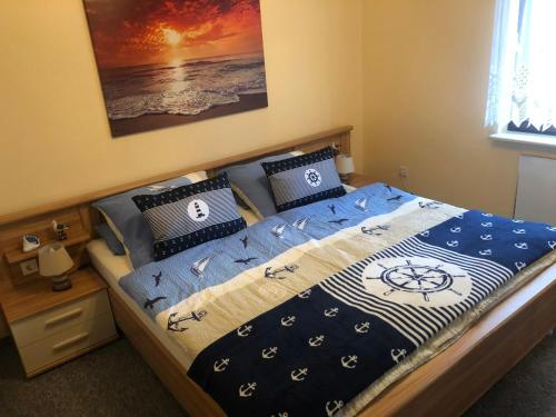 a bed with a blue comforter and pillows at Breeger Boddenhuus in Breege