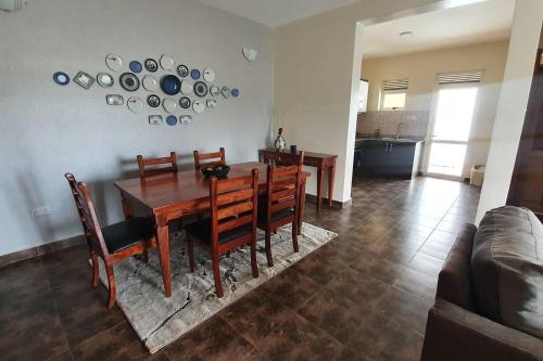 a dining room with a wooden table and chairs at Charming 2-Bed Apartment in Kigo in Kampala