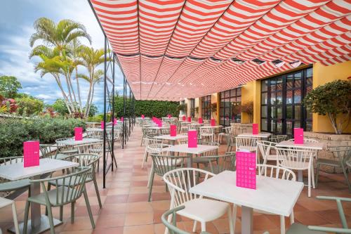 a row of tables and chairs with pink signs on them at Allegro Isora in Puerto de Santiago
