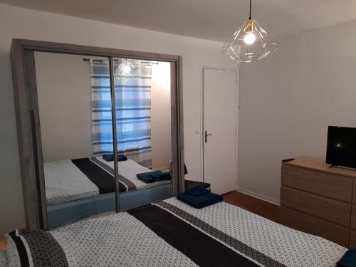 une chambre avec deux lits et un miroir dans l'établissement Appartement ORANGE, à Reims