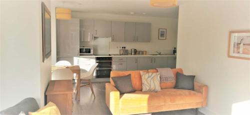 Apartment 9 Estuary Reach في اكسماوث: غرفة معيشة مع أريكة ومطبخ