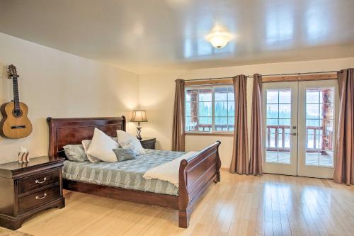 Kettle Falls Home with River Valley Mtn Views! في Kettle Falls: غرفة نوم مع سرير وجيتار على الحائط