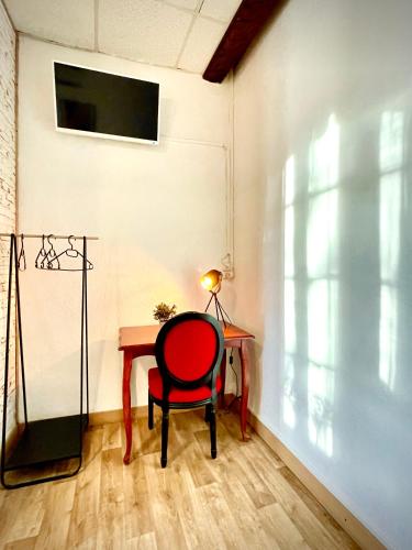a red chair sitting at a table in a room at Hôtel Paul Riquet in Béziers