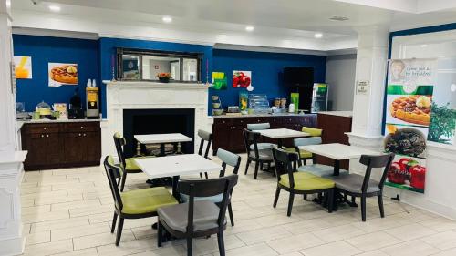 a restaurant with tables and chairs and a fireplace at Quality Inn & Suites 