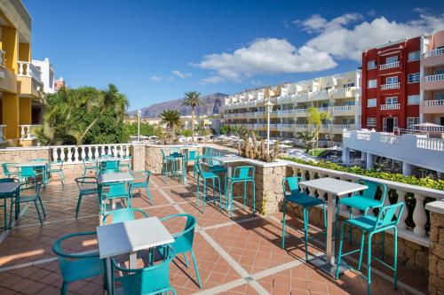 a patio at a hotel with tables and chairs at Allegro Isora in Puerto de Santiago