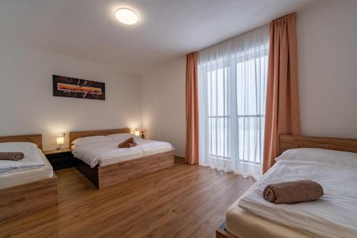 1 Schlafzimmer mit 2 Betten und einem großen Fenster in der Unterkunft Apartmán na Bukovce MALMA in Červená Voda