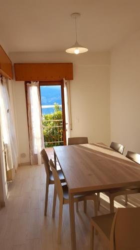ein Esszimmer mit einem Tisch, Stühlen und einem Fenster in der Unterkunft casa Leo in Magugnano-Marniga