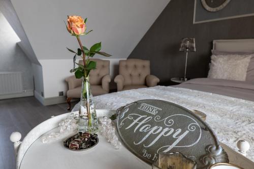 a vase with a flower on top of a bed at Tussen Hemel en Maas in Dilsen-Stokkem