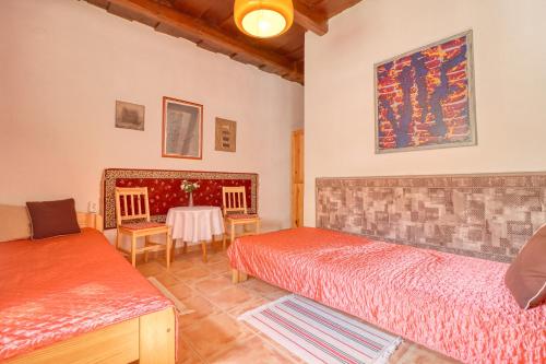 a bedroom with two beds and a table at Napfény Vendégház in Bükkszék